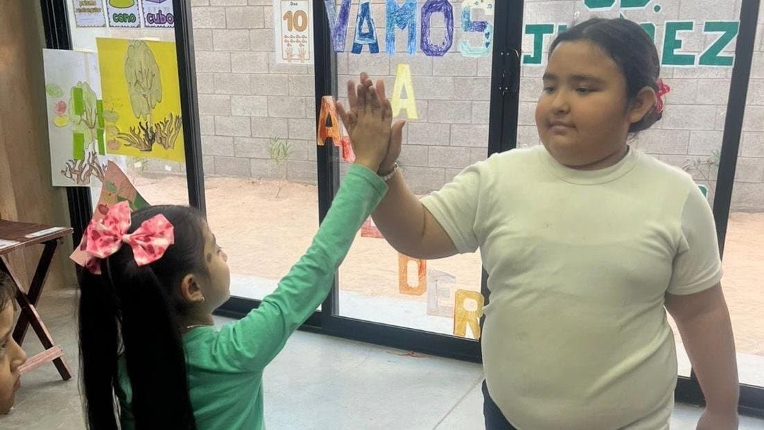 Zoe chocando las manos con una compañera en el Colegio San Isidro